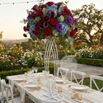 Load image into Gallery viewer, Decorative floral arrangement on a white stand with a garden setting
