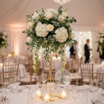 Load image into Gallery viewer, Decorative floral arrangement on a table with candles and glasses in a wedding reception setting.

