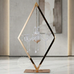Load image into Gallery viewer, Decorative chandelier with geometric brass frame on a marble floor.
