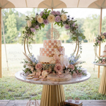 Load image into Gallery viewer, Decorative cake with floral arrangements on a table outdoors
