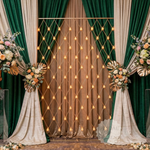 Load image into Gallery viewer, Decorative setup with green and beige curtains, floral arrangements, and string lights.
