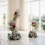 Load image into Gallery viewer, Floral arch and decorations in a bright room with large windows.
