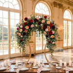 Load image into Gallery viewer, Decorative floral arch with red, pink, and green flowers in a grand room with large windows.
