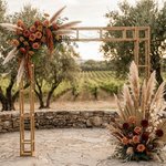 Load image into Gallery viewer, Decorative floral arch with pampas grass and roses in a vineyard setting.
