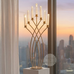Load image into Gallery viewer, Decorative gold candelabra with candles in front of a window with a cityscape view.
