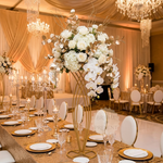 Load image into Gallery viewer, Decorative floral arrangement on a table with gold tablecloth and white chairs in a banquet hall.
