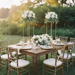 Load image into Gallery viewer, Outdoor wedding setup with wooden table, white flowers, and chairs with white cushions.

Flower Stand, Wedding Centerpiece, Geometric Stand, Pedestal Stand, Floral Riser. Gold Metal Stand, Heavy Duty, Modern Wedding Decor, Event Centerpiece, Aisle Pedestal, Collapsible Stand.
