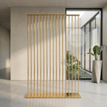 Load image into Gallery viewer, Gold metal screen in a modern interior setting with a plant and large window.
