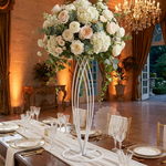 Load image into Gallery viewer, Decorative floral arrangement on a white stand in a formal dining setting with a chandelier.
