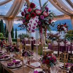Load image into Gallery viewer, Decorative floral arrangements on tables with a scenic background
